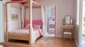 A high-detail bedroom in the Barbie Dreamhouse with a canopy bed, pink headboard, and a glimpse of the ensuite bathroom.