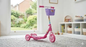 A pink Disney Princess themed three-wheeled scooter with a front basket, suitable for a 4-year-old’s outdoor activities.